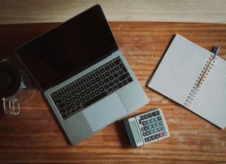 Ordinateur portable et factures papier posés sur un bureau