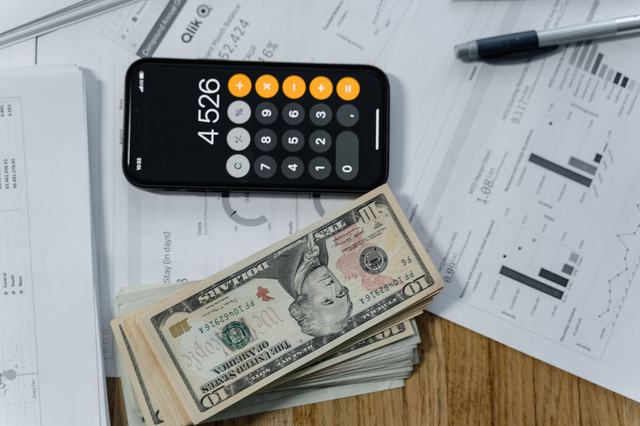 Trésorerie d’une entreprise : définition, calcul et suivi Calculatrice, billets et documents financiers sur un bureau : suivre la trésorerie de son entreprise